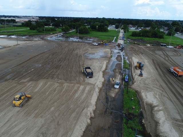 a drone shot of trucks full of sand next to workers