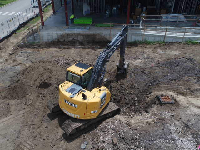 an excavator digs on a jobsite