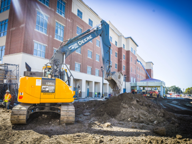 ochsner-4a the back of an excavator digging at a pile of dirt
