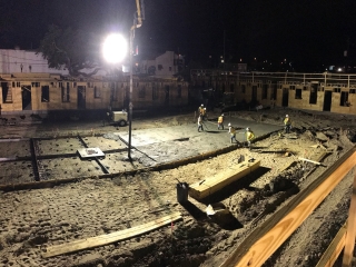 workers pour concrete late at night